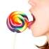 9377985-closeup-of-young-brunette-girl-licking-big-multicolored-lollipop-side-view-isolated